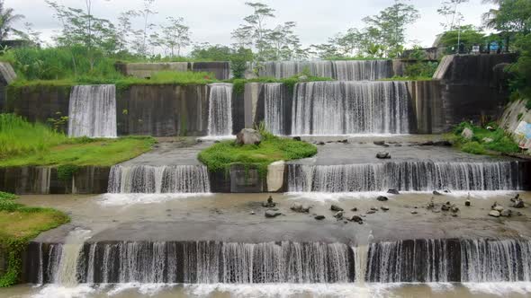 Aerial backwards view over Watu Purbo waterfall in Muntilan, Indonesia alt