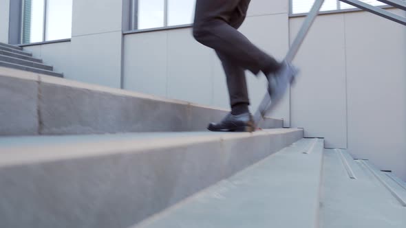 close up of business man steps up stairs. Male businessman walks up the stairs alt