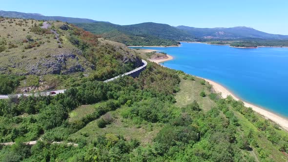 Aerial view of paved road passing artificial lake of Peruca, Croatia alt