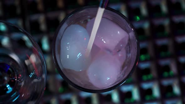 Making a cocktail. View from above. Pouring Liqueur into a Glass with Ice. alt
