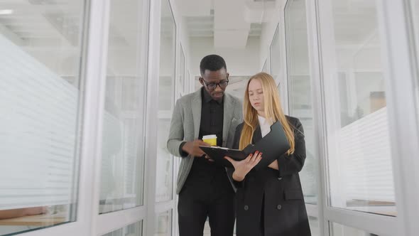 Two Students Diverse Race and Nationality Work and Study Together Discuss Paper