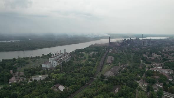 Aerial View of the City Near a Large Industrial Plant with Pipes and Smoke alt