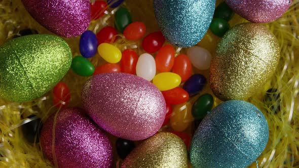 Rotating shot of Easter decorations and candy in colorful Easter grass  alt