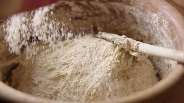 BAKING - Sprinkling flour over batter, sourdough bread, slow motion zoom in alt