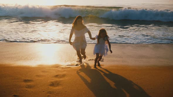 Happy Middle Aged Mother and Little Daughter Running Away From Big Wave Together Having Fun alt