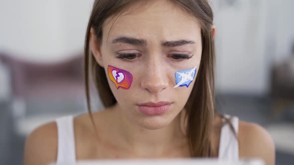 Portrait of Young Attractive Woman Looking Sadly at the Tablet alt