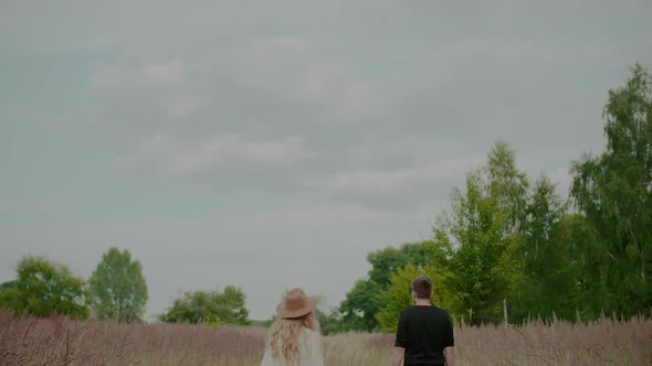 Girl Hugs Her Lover Holding a Bouquet of Wildflowers alt