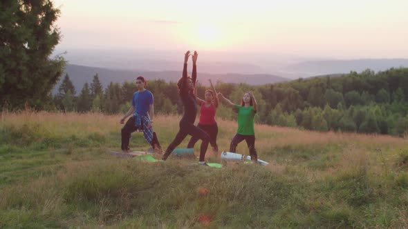 Diverse Multiracial People with Fitness Trainer Doing Yoga Crescent Moon Pose on Mountain Top at alt