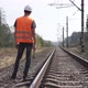 The railway worker stands along the railway tracks, holding a sledgehammer in his hands. - VideoHive Item for Sale