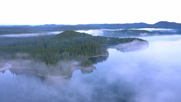 Fly over the morning fog over the mountain lake, Rodopi mountain Bulgaria alt