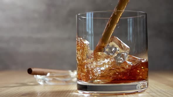 Jet of Whiskey in a Glass With Ice
