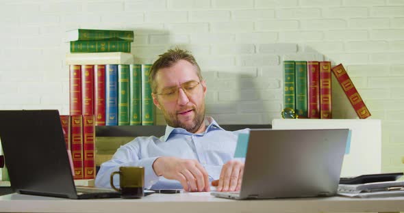 Middleaged Man is Lounging in the Office  He Makes a Paper Airplane and Launches It alt