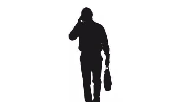 Silhouette Of Businessman with Suitcase Talking On Phone While Walking To Office