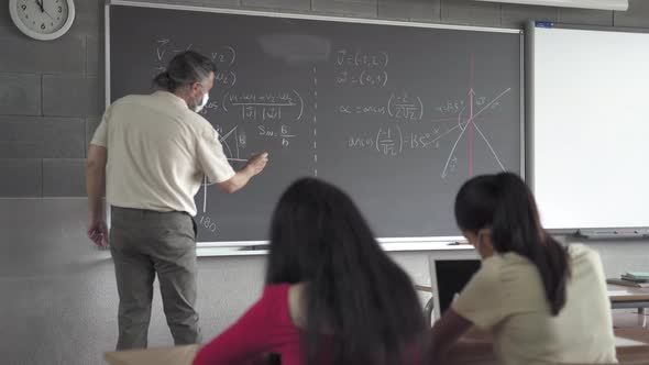 Secondary School Maths Teacher and Students Wearing a Protective Face Mask in the Classroom alt