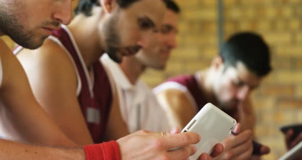 Coach and basketball players using digital tablet alt