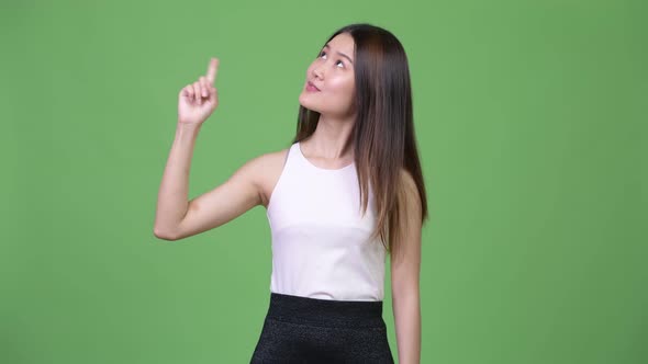 Young Beautiful Asian Businesswoman Thinking While Pointing Up