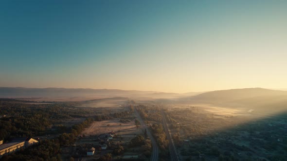 Cinematic Aerial Drone View of Hazy Mountain Walley at Sunrise alt
