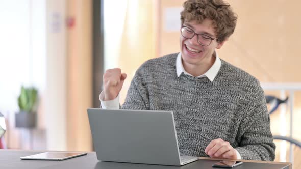 Excited Young Man Celebrating Success on Laptop  alt