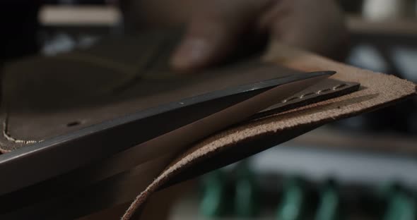 Close Up View of Tailor Cut Leather with Scissors Preparing Blanks for Making Shoes Slow Motion