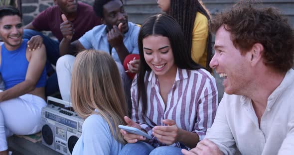 Young diverse people having fun in the city while listening music from vintage boombox alt