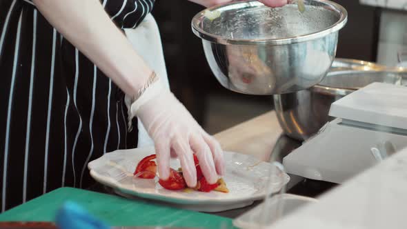 Chefs in Protective Masks and Gloves Prepare Food in the Kitchen of a Restaurant or Hotel High alt