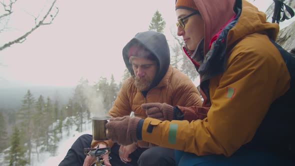 Couple Drinking Hot Tea at Campsite in Mountains alt