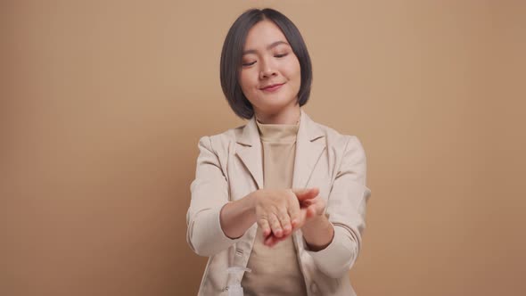 Asian business woman putting hand sanitizer on hands for washing her hands isolated