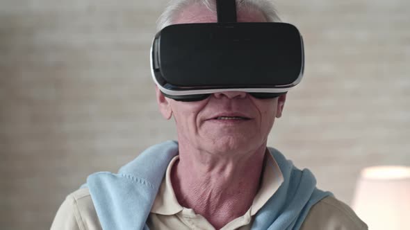 Curious Elderly Man Looking Around in VR Headset alt
