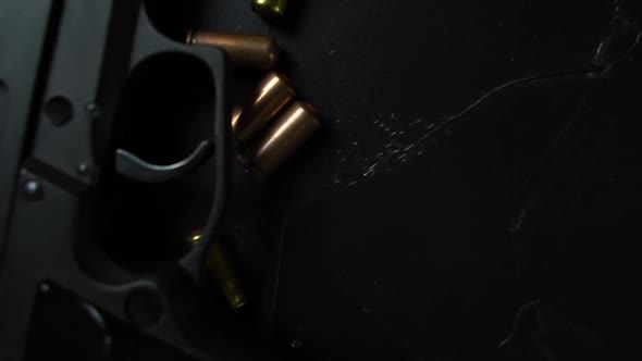 Firearms and Ammunition Lie on a Black Textured Table