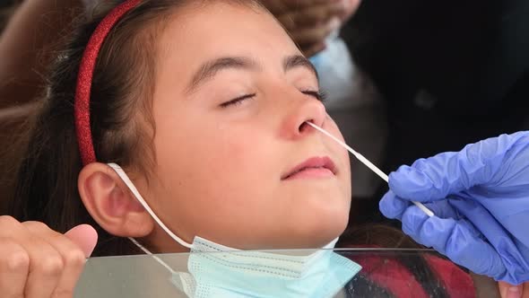 Pediatrician Taking Nasal Mucus Test Sample From Elementary Age Girl's ...