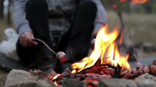 Girl is Preparing Sausages on Campfire alt