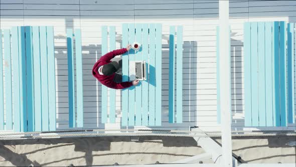 Male Freelancer Working on a Laptop While Sitting in a Cafe on Vacation alt