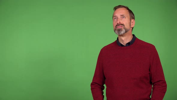 A Middleaged Handsome Caucasian Man Looks Around in Thought  Green Screen Background