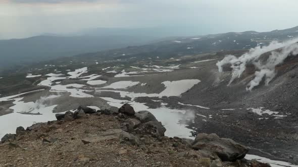 Hot steam geysers on mountain slope of active volcano Mount Asahidake in Japan alt