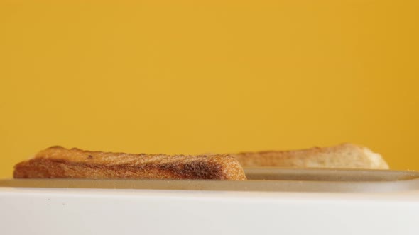 Burned pieces of bread pops up from  two-slot automatic electric toaster 4K video alt