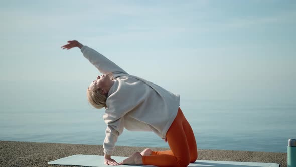 Young Woman Doing Morning Yoga Stretching on the Sea