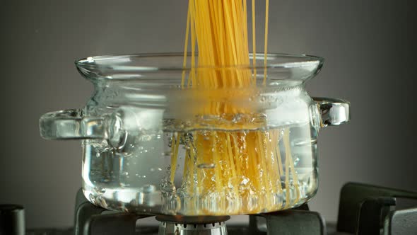 Super Slow Motion Shot of Fresh Spaghetti Falling Into Boiling Salted Water at 1000 Fps alt