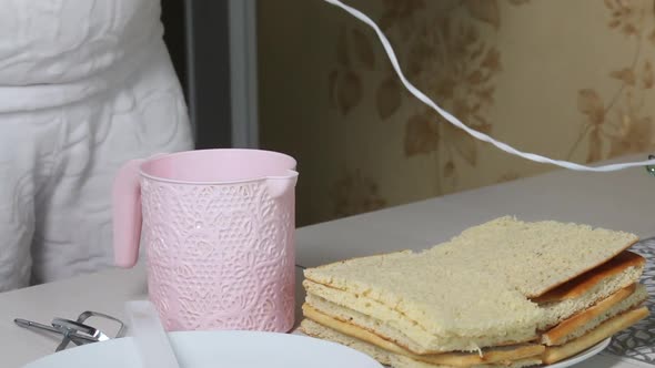 A Woman Sets Whisks On A Mixer. On The Plate Are Pieces Of Freshly Baked Biscuit. alt