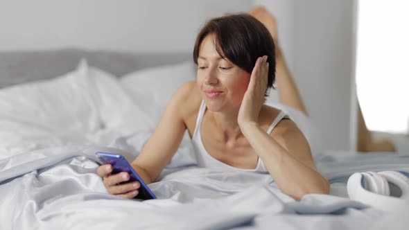 Woman Using Smartphone in Bed