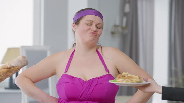 Portrait of Young Overweight Woman Refusing Unhealthy Junk Food Shaking Head No Looking at Camera alt