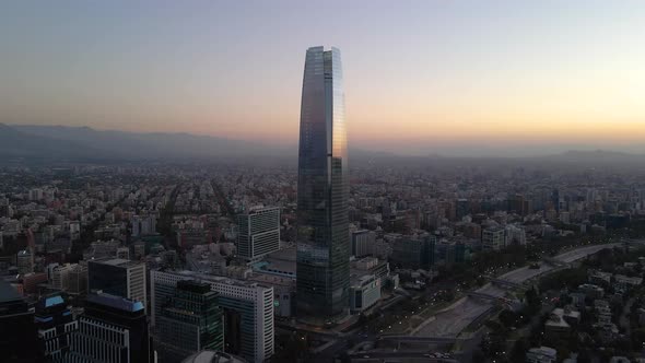Aerial dolly out of Costanera Center skyscraper and Mapocho river in modern Sanhattan area at blue h alt