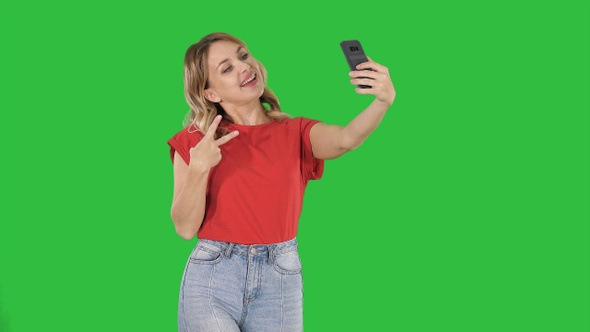Joyous woman 30s wearing red t-shirt taking selfie photo alt