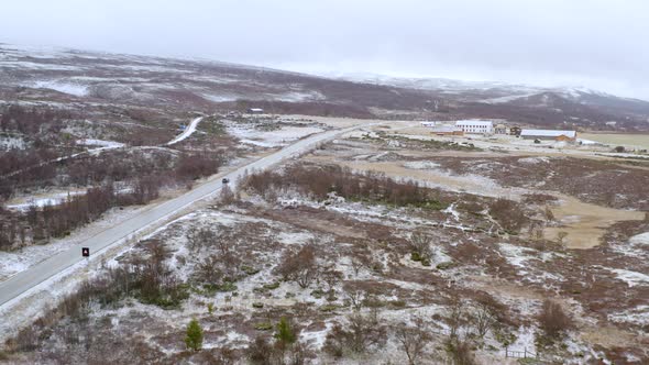 Vehicle Driving Through Dovre Mountains During Winter In Norway - aerial panoramic alt