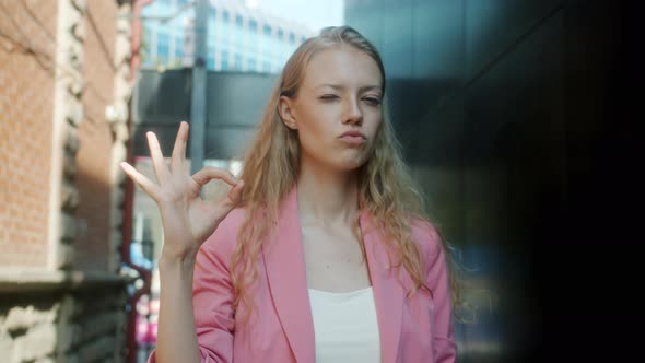 Portrait of Beautiful Girl with Long Blond Hair Showing Ok Hand Gesture Looking at Camera with Happy alt