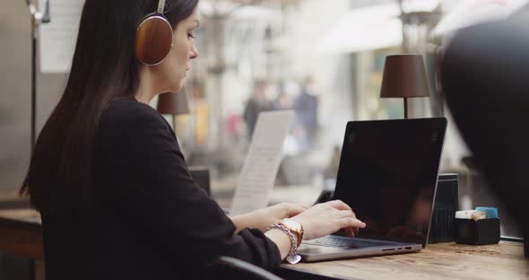 Back View of Caucasian Woman Working on a New Project in a Coffee Shop