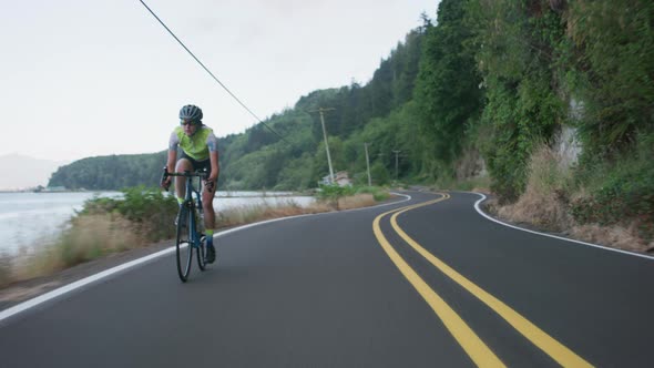 Tracking shot of a female cyclist on country road.  Fully released for commercial use.