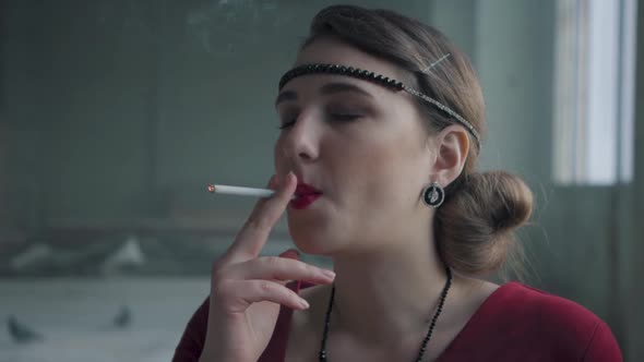 Portrait Confident Young Woman in Old Style Cloth Fire the Sigaret. Slow Motion. Abandoned alt