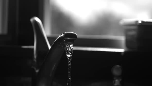Water pouring from a faucet in ultra slow motion alt