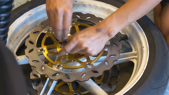 Close-up Footage of Mechanic Working On Disc Brake Installation For Motorcycle alt