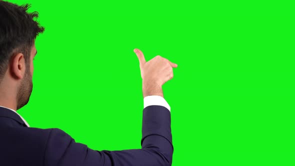 Businessman working on digital screen. Green background. alt